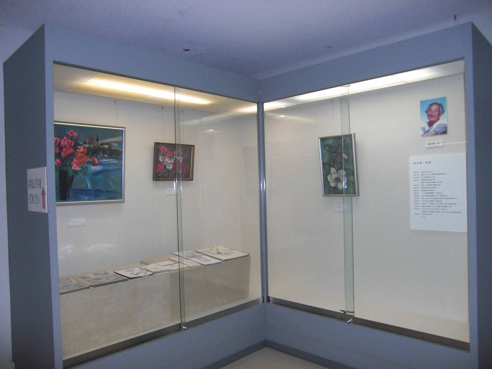 福井敬一常氏の経歴と花の絵画が展示された展覧会の写真