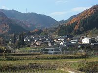 山々を背景に仙仁川の谷沿いには集落が広がる仙仁地区の写真