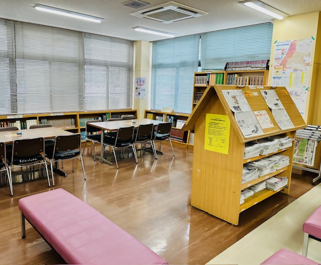 テーブルと椅子および新聞が置かれた棚の写真