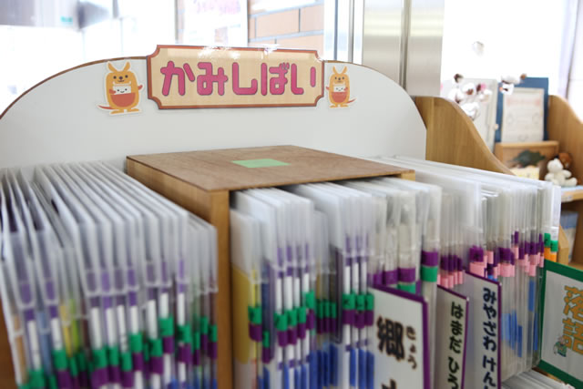 「かみしばい」と書かれたラベルの下に置かれている分類わけされた紙芝居コーナーの写真