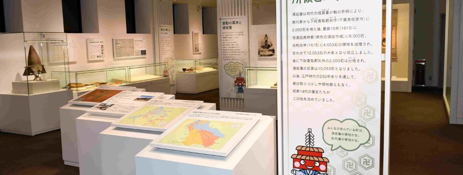 イラストや地図、説明書が書かれたパネルやガラスケースに入った多くの資料が展示されている3階の展示室の写真