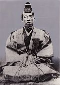 腰に刀を差して座っている堀直虎の写真