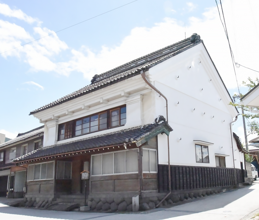 信陽銀行の建物、瓦屋根、しっくい壁の蔵のような建物。二階建て。