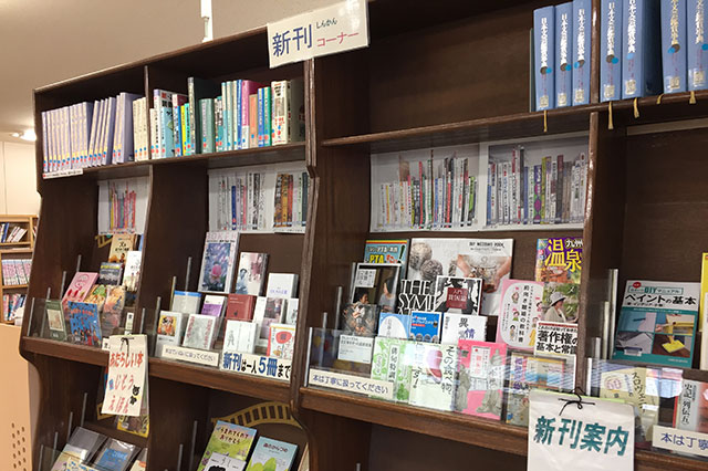 木製の本棚に並べられた新刊コーナーの写真