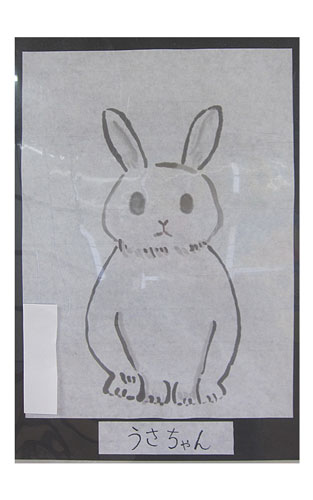 両耳を立てて真正面を向いて座っているウサギを描いた墨絵の作品