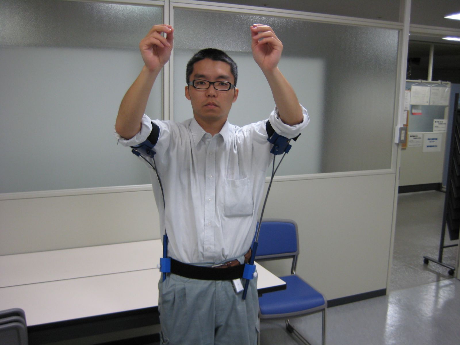 二の腕にブドウ作業用補助具「グレイパー」を装着し、房切りをする体制をしている男性の写真