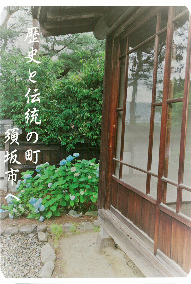 歴史と伝統の町 須坂市と書かれ、庭に紫陽花が咲き、木造の古い建物でガラスの窓が一面にある歴史的建物の外観の写真のポストカード