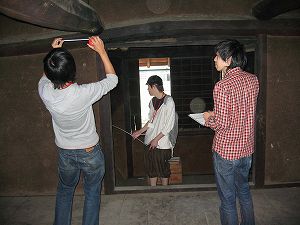男性3人で梁などの寸法を測ったり現地調査している様子の写真