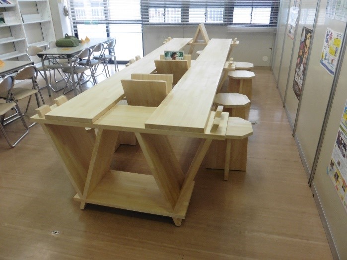 部屋の一室に設置された組子の三角形をモチーフに作成されたテーブルと八角形の椅子の作品の写真