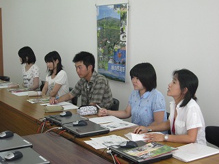 設置されたテーブルの席についている大学生4名と教員1名の写真