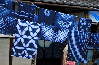 作成された様々な模様の藍染の手ぬぐいが干されている写真