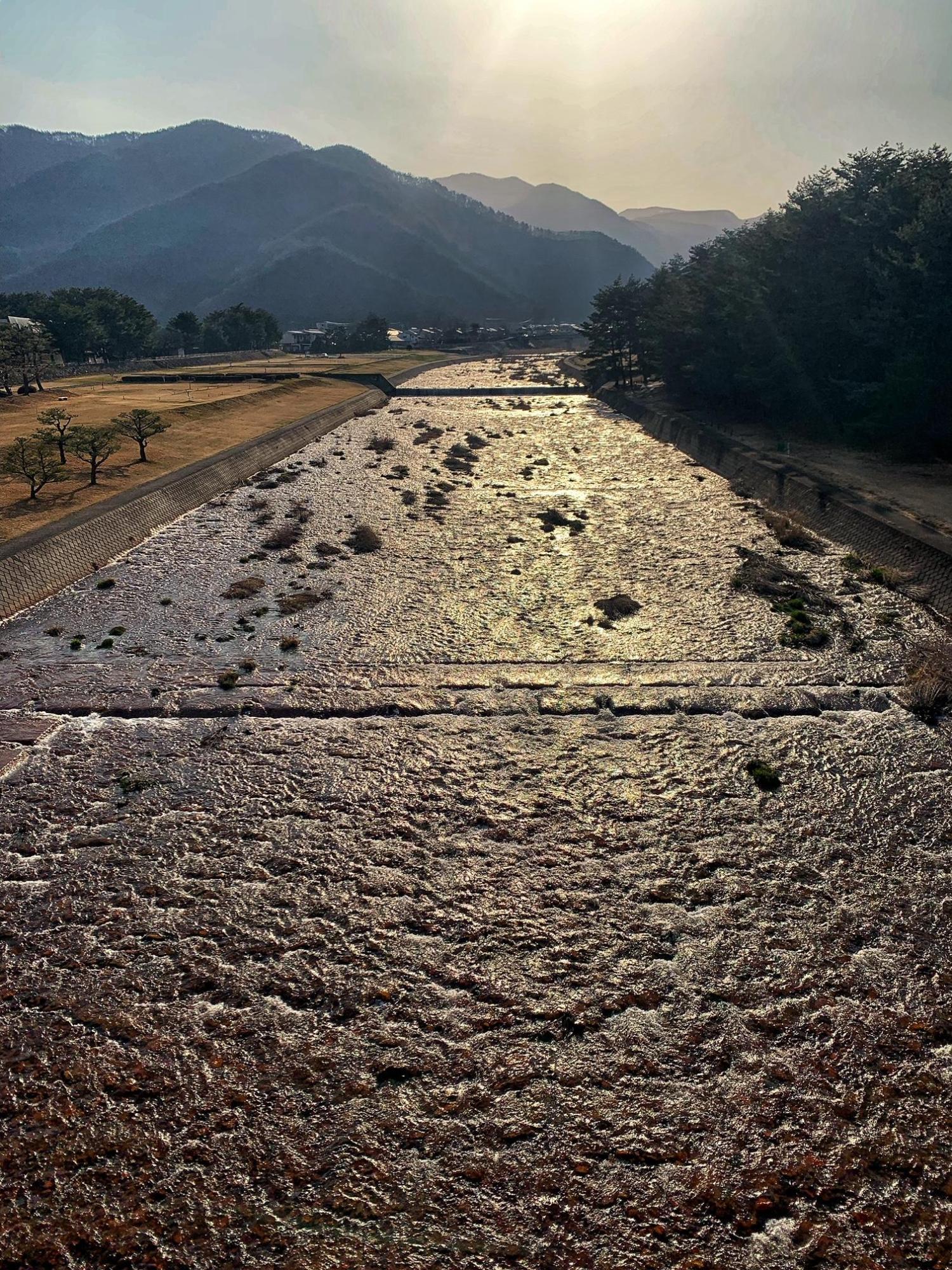 どどがわとりょくちの写真。正面には高山方面、夕日に照らされたどどがわの川面がキラキラしている。