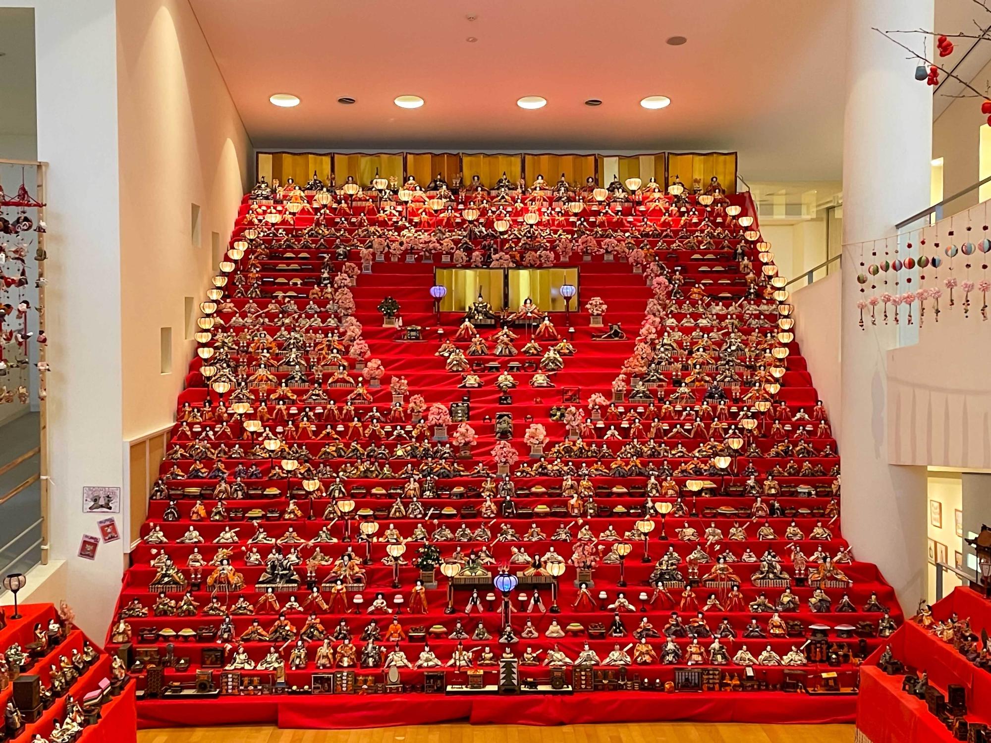 アートパーク、世界の民俗人形博物館で1月から3月ころに開催される、ひなまつりの写真、30段に組まれたひな壇に、数百体のひな人表がずらりと並ぶ。天井まで届くひなだんは迫力満点