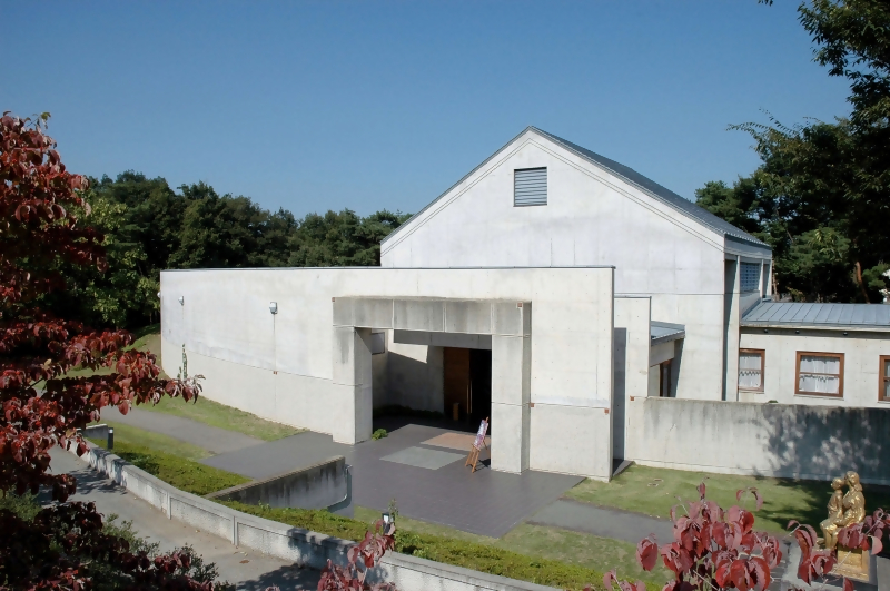 アートパークの須坂版画美術館の外観写真。白いコンクリート壁に覆われた建物、モダンだが古い印象。