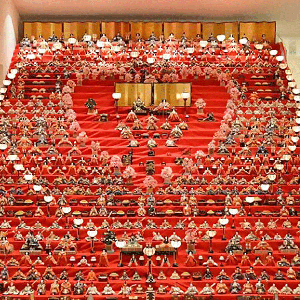 三十段飾り千体の雛祭りの写真。天井まで届く30段のひな壇に、びっしりと並ぶひな人形たちに圧倒される。ぼんぼりをハート形に並べてありかわいい。