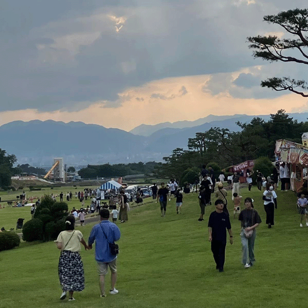みんなの花火大会までの時間、芝生部分で場所取りをしたり、屋台を見て歩く人の写真