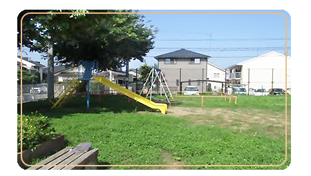 所々草がはえ、左に黄色い滑り台、その奥に白いブランコがある長者公園の写真