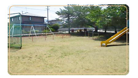 右側に木と滑り台があり、左側にブランコと柵が設置されている田の神公園の写真