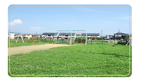 綺麗な青空の下、中央に吊り輪ジム、左側にブランコがある郷原公園の写真