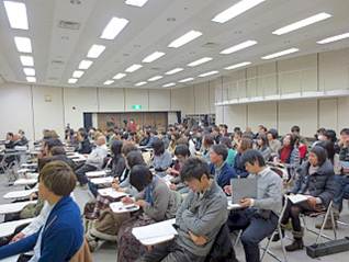 パイプ椅子に座って蔵の町並みキャンパス成果発表を聴く参加者の写真