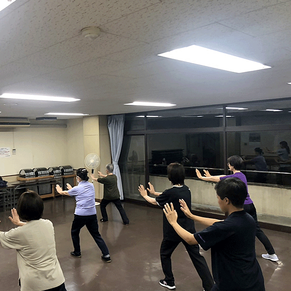 ヘルシーライフ太極拳の様子。会議室のような場所で、老若男女が太極拳をしている写真