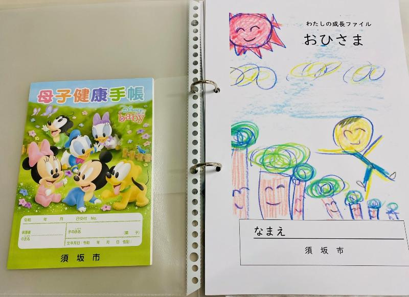 わたしの成長ファイル「おひさま」と母子健康手帳の写真。クリアファイルにわたしの成長ファイルが入れてある。A4サイズ。母子健康手帳と一緒に保管しておくと便利
