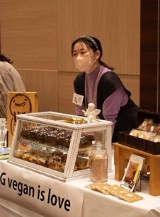 ソルガムマルシェにて接客する小山美和子さんの写真