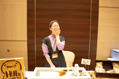 左手を口元に手を添えて笑う小山美和子さんの写真