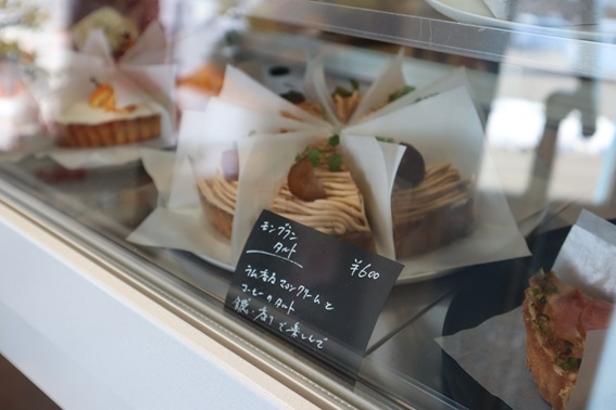 ショーケースに入った黒色のPOPとモンブランタルトの写真