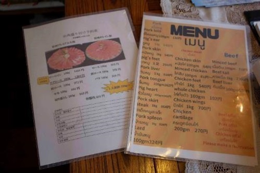 日本語で書かれた白のメニュー表とタイやベトナムの方専用のオレンジ色のメニュー表が並んだ写真