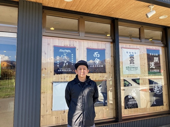新崎酒店前で撮られた新崎 孝志さんの写真