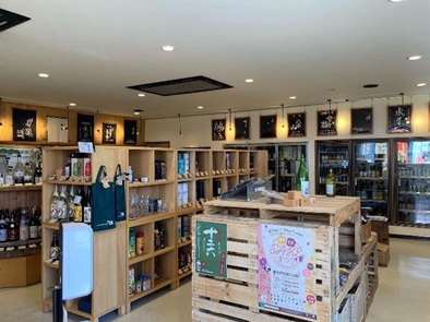 冷蔵庫や木製の棚に商品が陳列された新崎酒店の店内写真