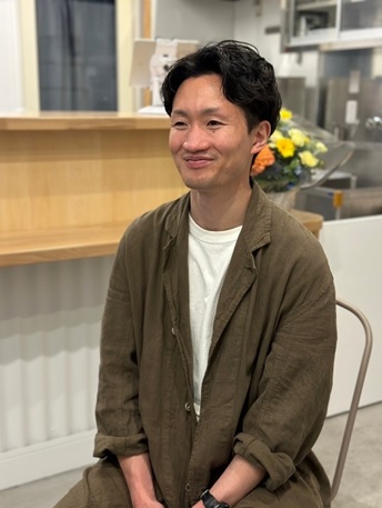 椅子に座ってほほ笑む土屋裕太さんの写真