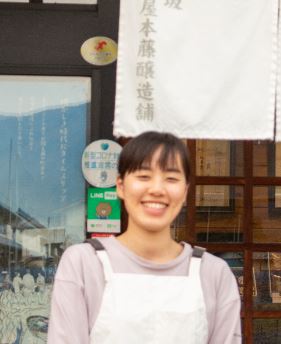 糀屋本藤醸造舗前でほほ笑む鈴木はるなさんの写真
