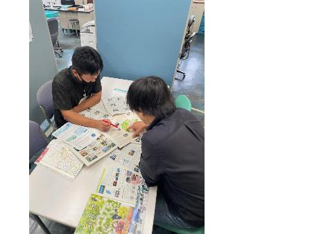 移住担当者が黒シャツの男性相談者に資料を見せながら説明しているところ