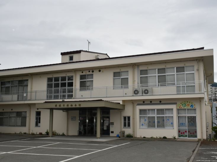駐車場が完備された2階建ての須坂市福祉会館の外観写真