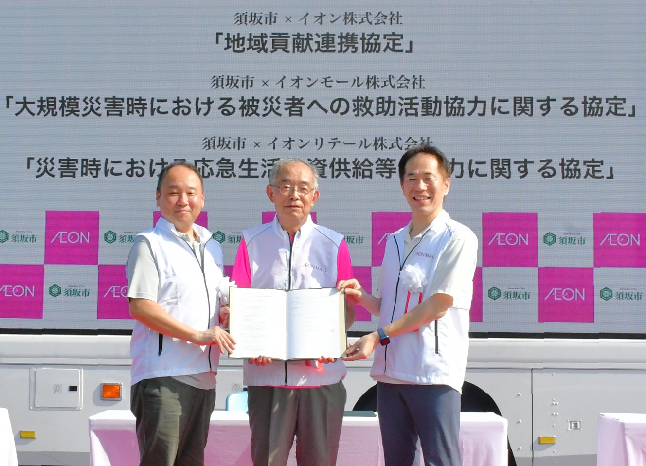 市長、イオンモール株式会社関係者、イオンリテール株式会関係者の3者で協定書を一緒に持ち、こちらを向いている