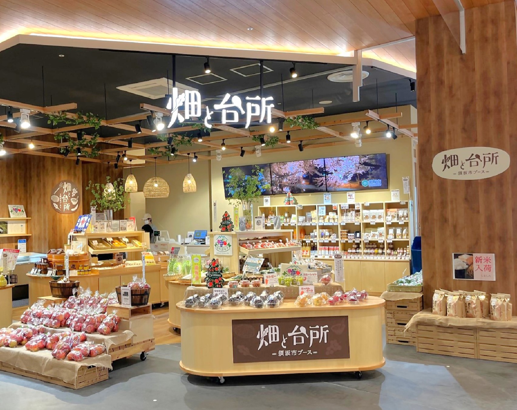 イオンモール須坂内の須坂市ブース、「畑と台所」のサインが光る店内に果物が陳列されている