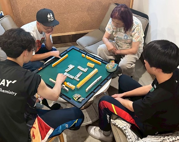 女性、男性、男子高校生2人でマージャンをしている。