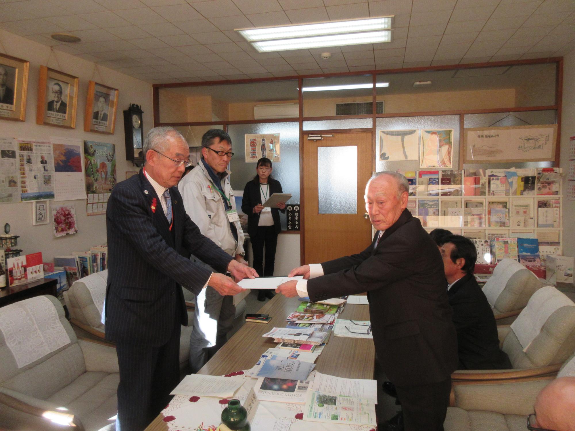 須坂市役所の応接室で、三木市長に意見書を手渡す農業委員会の皆さんの写真