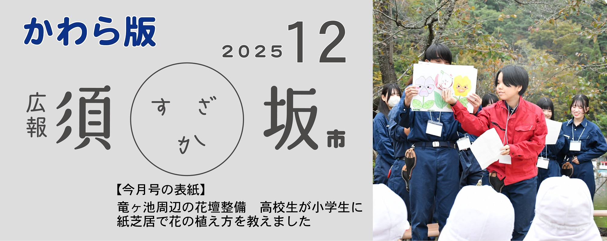 広報須坂12月号の表紙写真「竜ヶ池周辺の花壇整備、高校生が小学生に紙芝居で花の植え方を教えました」屋外で作業着を着た高校生たちが花の絵が描かれた紙芝居を演じている。手前に白い帽子をかぶった小学生の後ろ姿が見える。