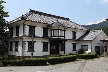 白壁っで一見和風だが、窓や破風が洋風でモダンな雰囲気の建物の写真