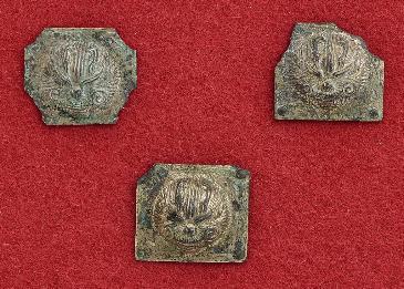金属でできたプレートのようなものが三つ映っている写真。それぞれ四角く、猫か、ライオンのような顔が立体的に描かれている。