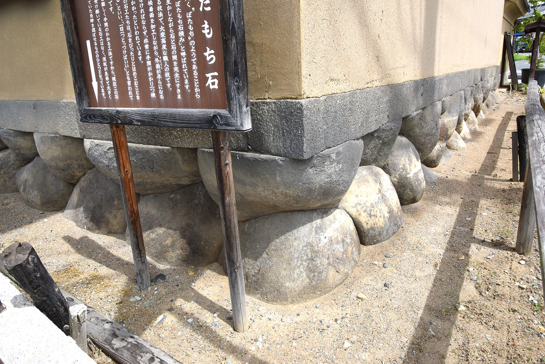 須坂の特徴的な景観のひとつ、ぼたもち石積みの写真。須坂クラシック美術館の外側の壁。説明版もたっている。