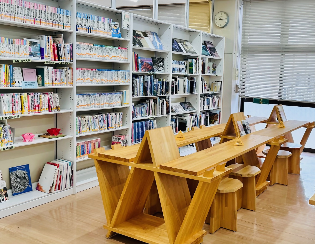 白い本棚に並んだ本と木製の机