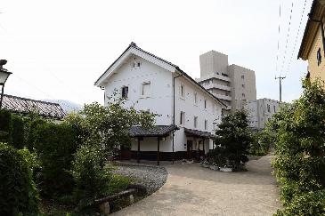 白壁の3階建ての大きな土蔵の写真。まわりは公園のように整備されている。