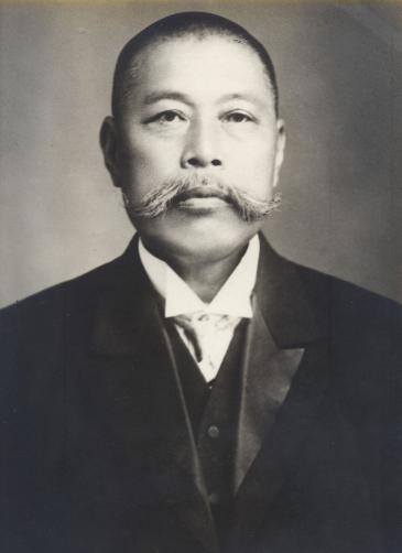 がらさわごいちろうの写真。坊主頭に立派な長い口髭をたくわえ、モーニング姿の上半身がうつる。