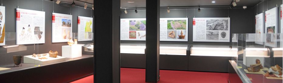 常設展示 考古展示室に土器や資料などが展示されライトアップされている写真