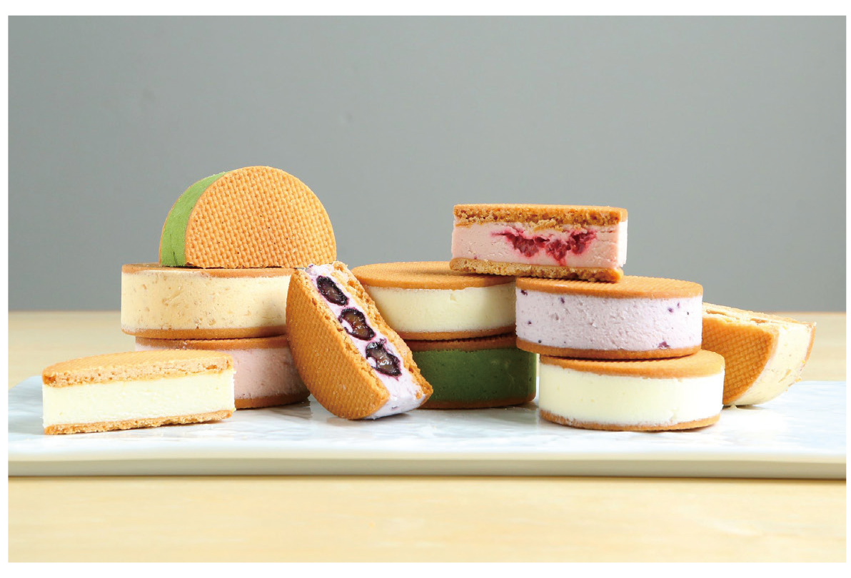 丸いビスケット生地にサンドされたイロトリドリのチーズケーキの写真