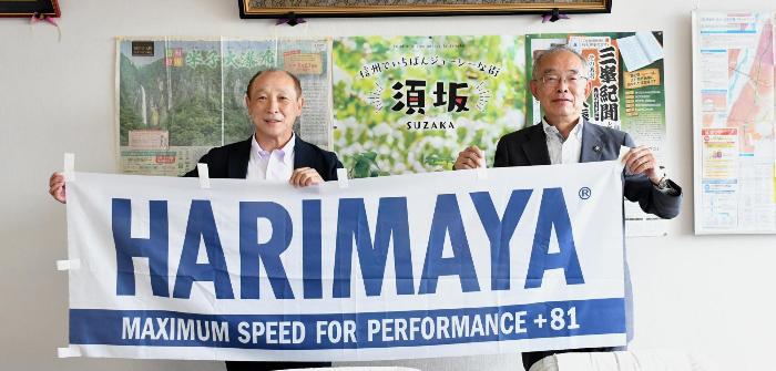 三木市長（右）と須藤社長（左）がハリマヤジャパン株式会社のロゴ旗を持っている写真